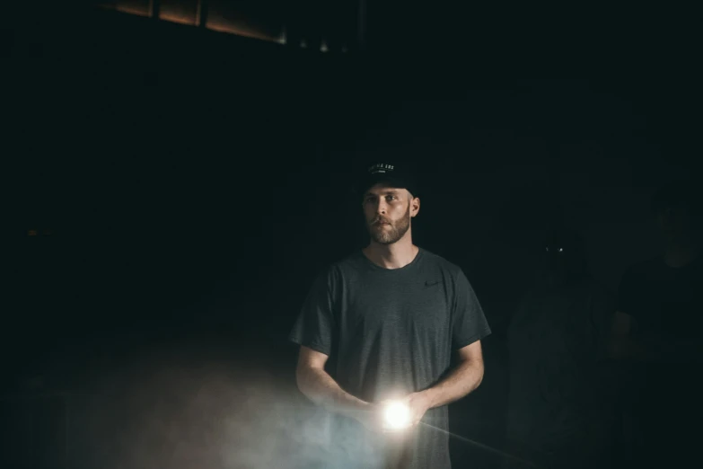 a man in the dark holding a glowing light