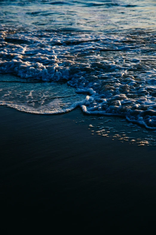 waves splash into the sand on a beach