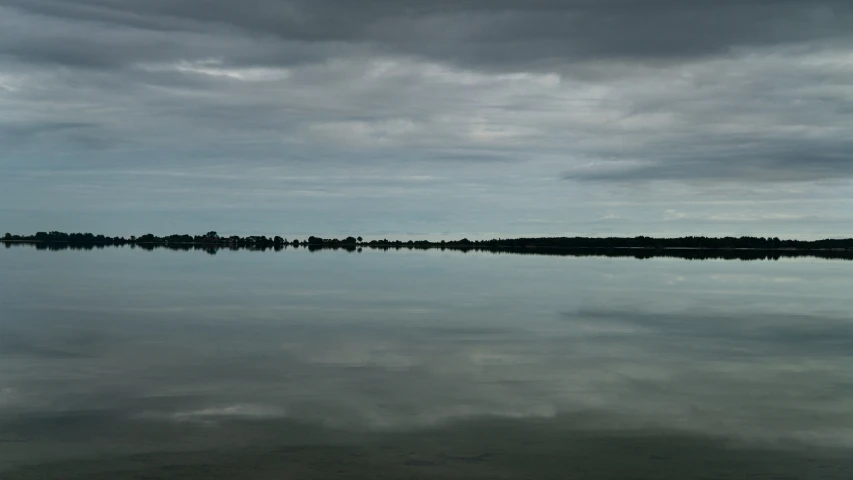 clouds are reflected in the calm lake water