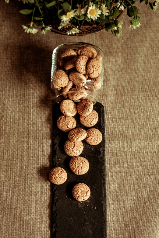 several cookies sit in a glass bowl next to flowers