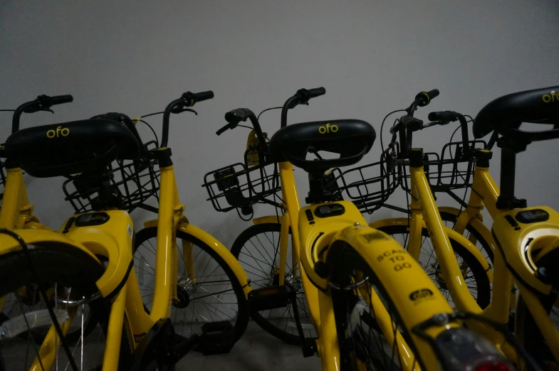 several yellow bicycles are lined up in the same row