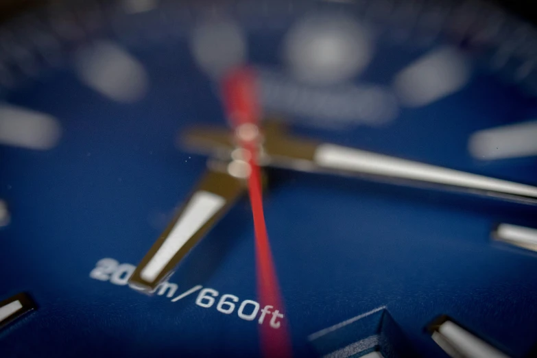 a closeup of a rolex watch showing the red hour mark