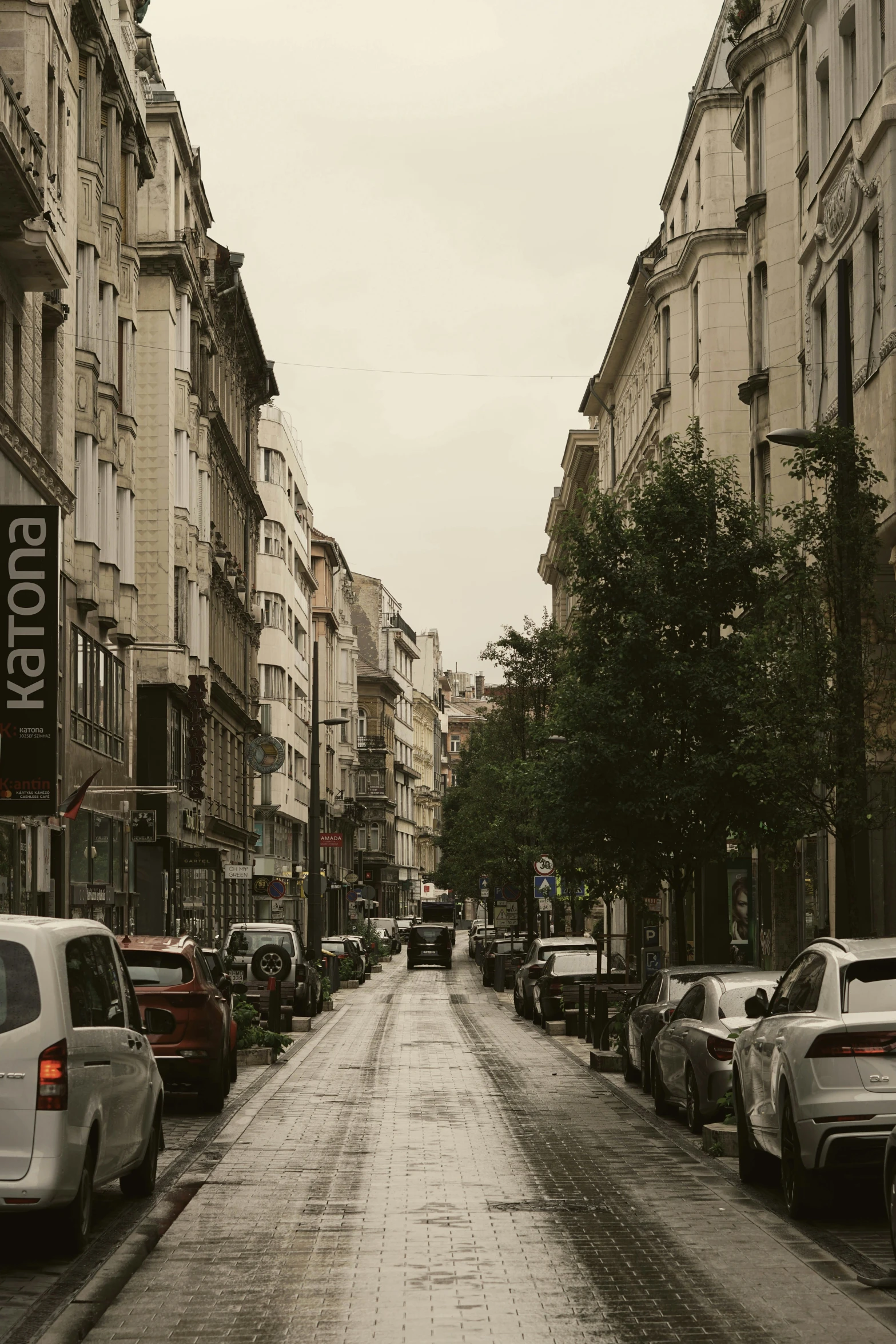 an empty street has cars and buildings on it