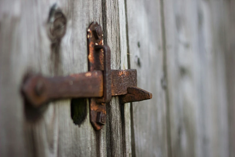 a lock on a wooden wall with some rusty keys