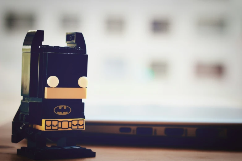 the lego batman standing up in front of his laptop