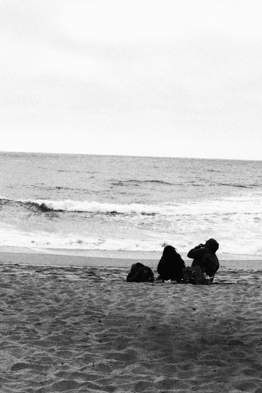 a group of people are laying in the sand on a beach