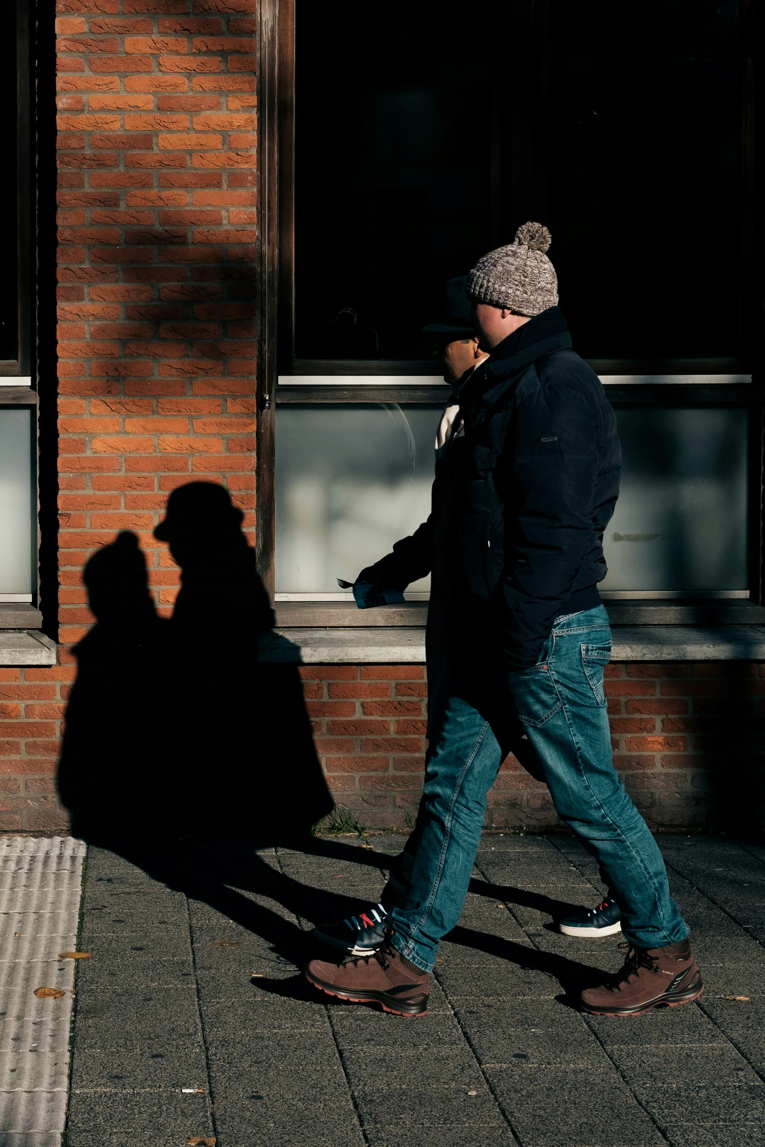 a man walks down the street past a building