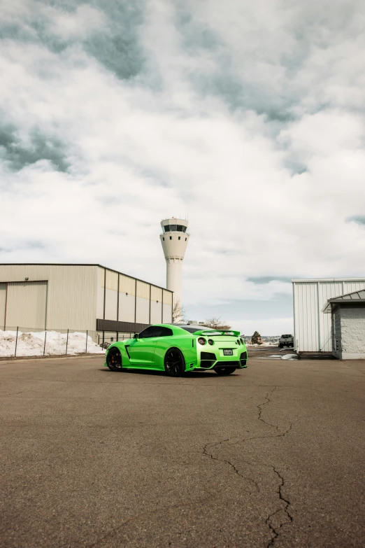 a green car parked in front of a control tower