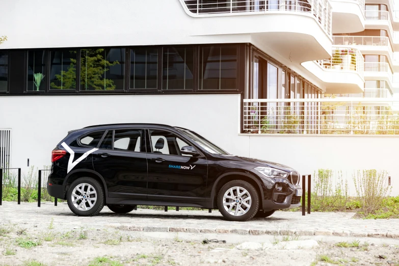 a small, black car parked in front of a building