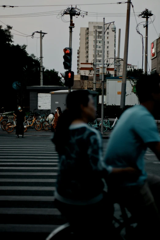 people in a crosswalk during twilight with buildings behind them