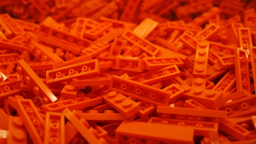 the large amount of orange legos are piled high