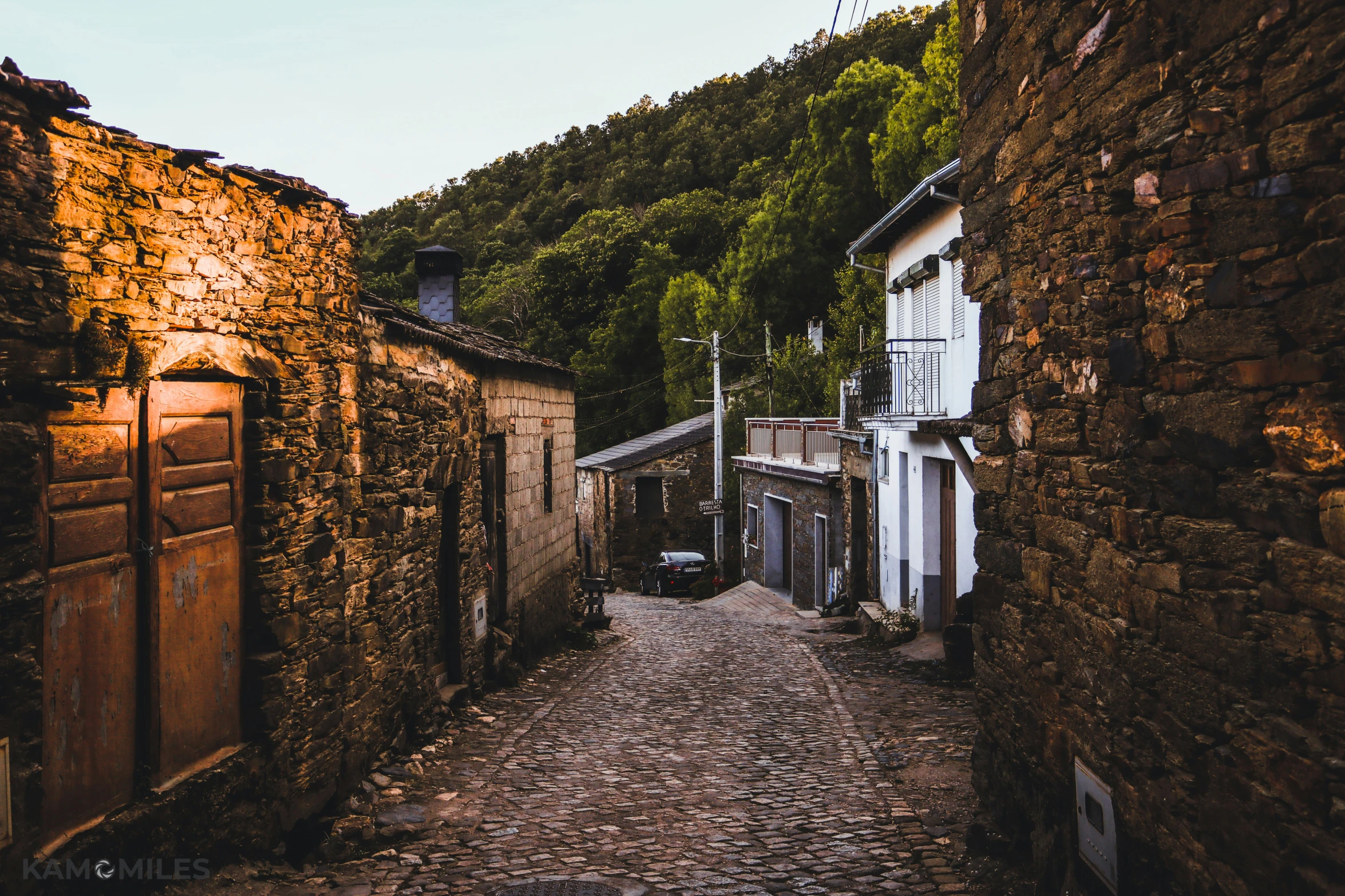 a stone street with doors leading to a small restaurant