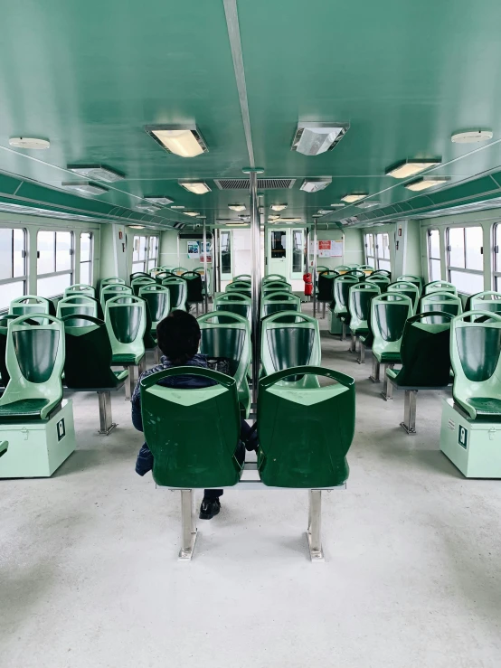 the interior of a green train with lots of seats