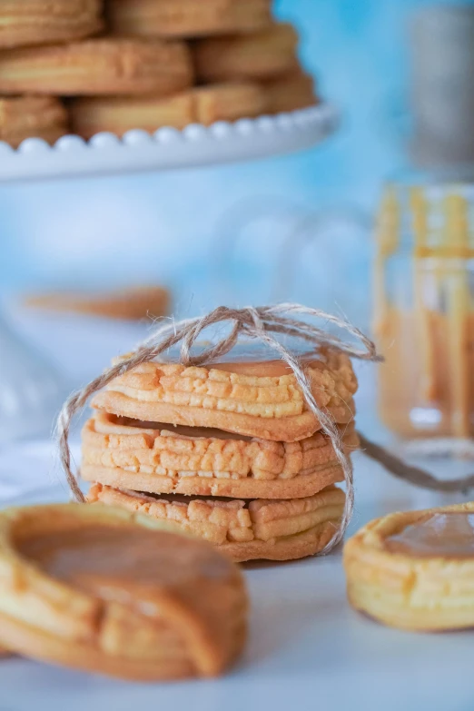 a stack of biscuits next to a plate with peanut er cookies on it