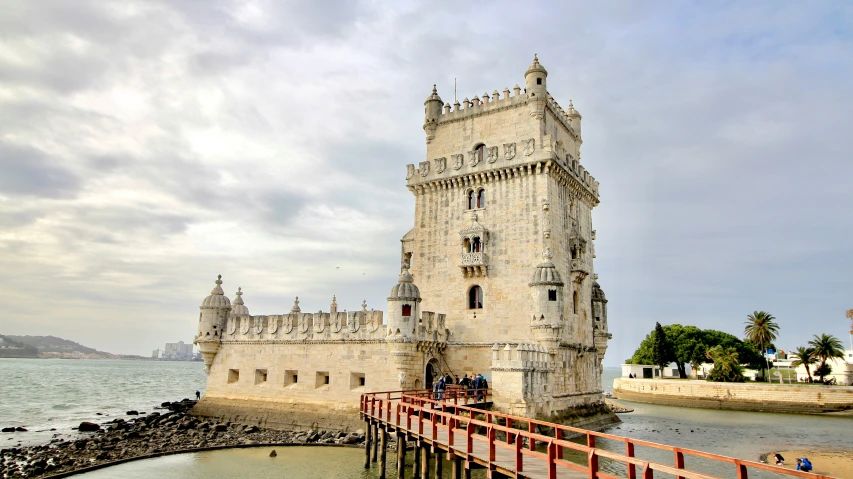 a castle with people on the balcony over water