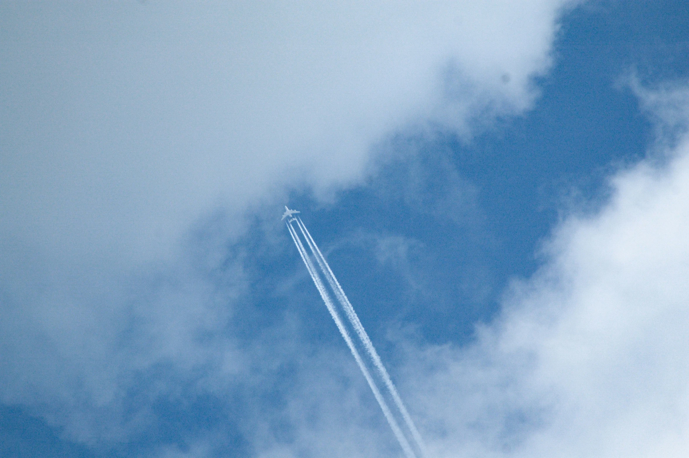 the tail ends of an airplane in the blue sky