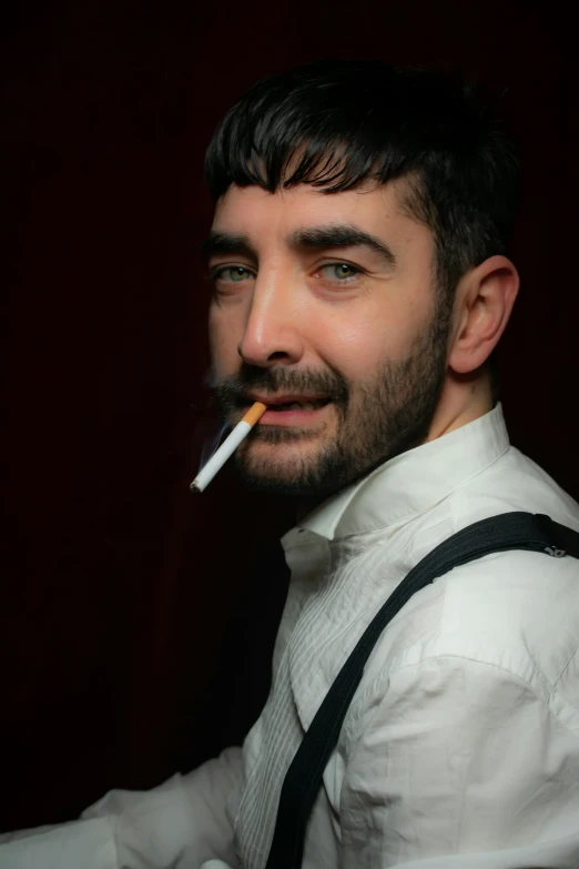a man smoking and smiling at the camera