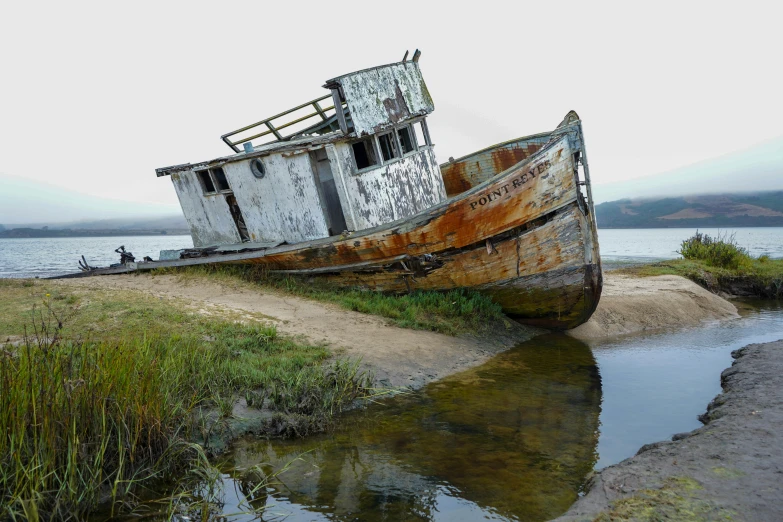 a boat sitting on top of grass covered land