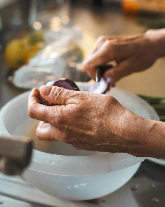 two hands holding up food on a plate