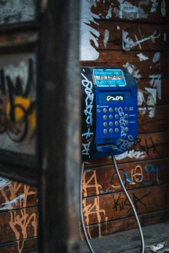 an old telephone sits in front of a graffiti covered wall