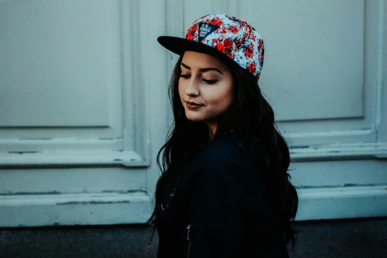 a woman wearing a baseball cap and black jacket