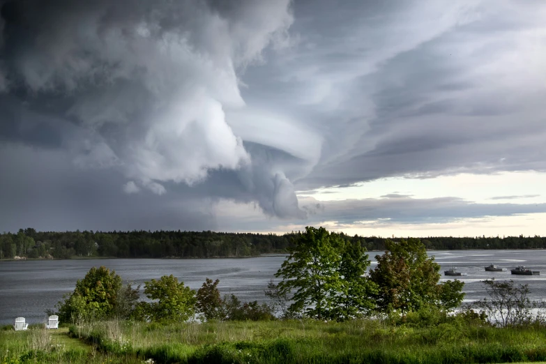 several boats under a storm moving over the water