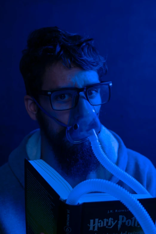 a man wearing an oxygen mask holding a book