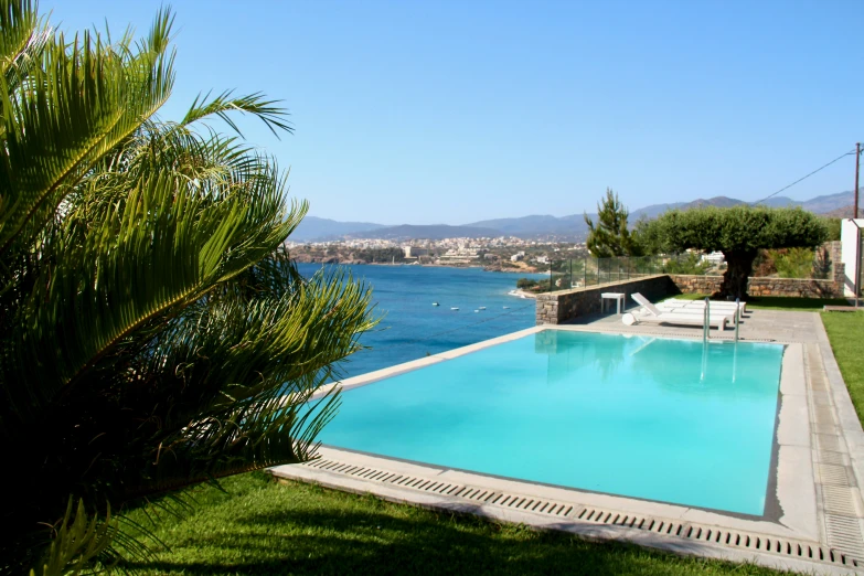 a pool next to the water near grass