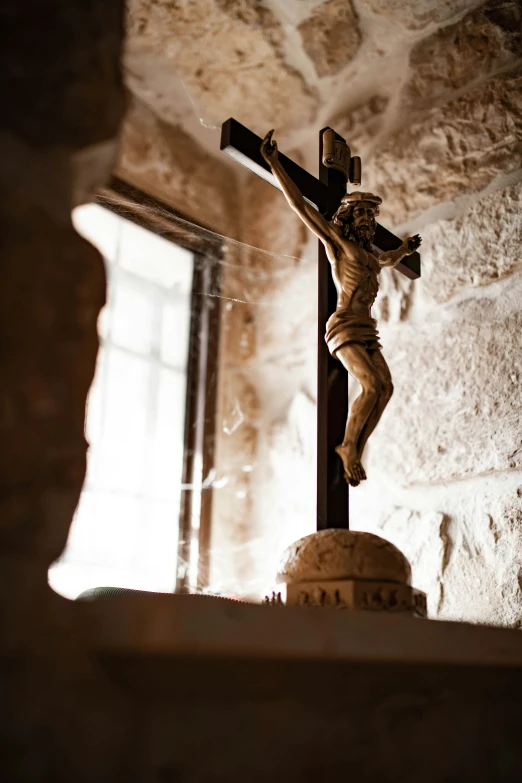 a crucifix with a stone wall and brick background