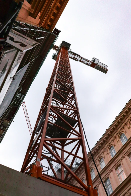 a tower near two buildings on a cloudy day