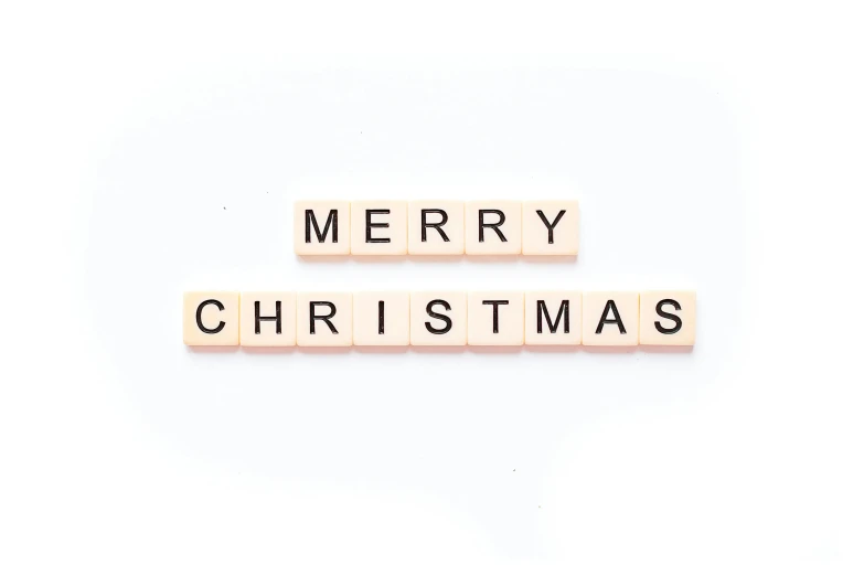 a couple of scrabble tiles spelling out merry christmas