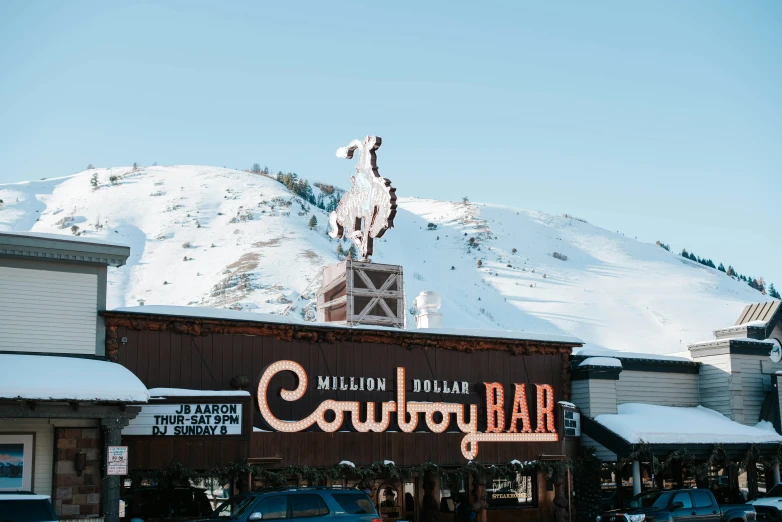 a large building with an old fashioned cowboy ranch sign on top