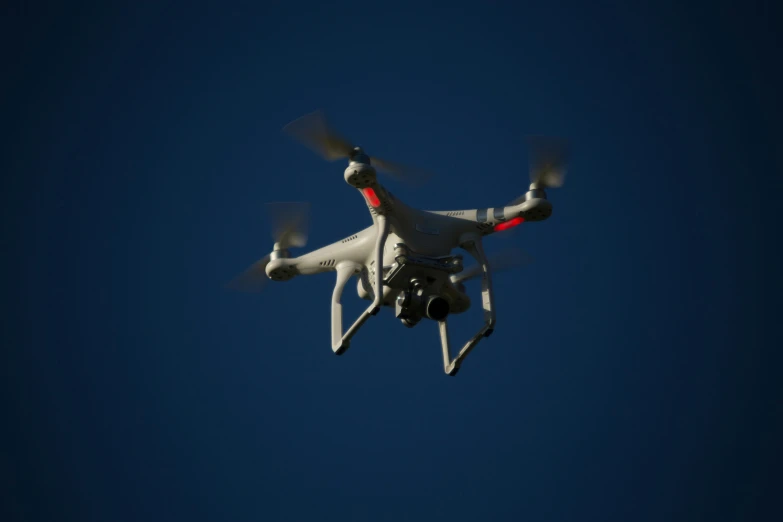 a small white helicopter flying through the sky