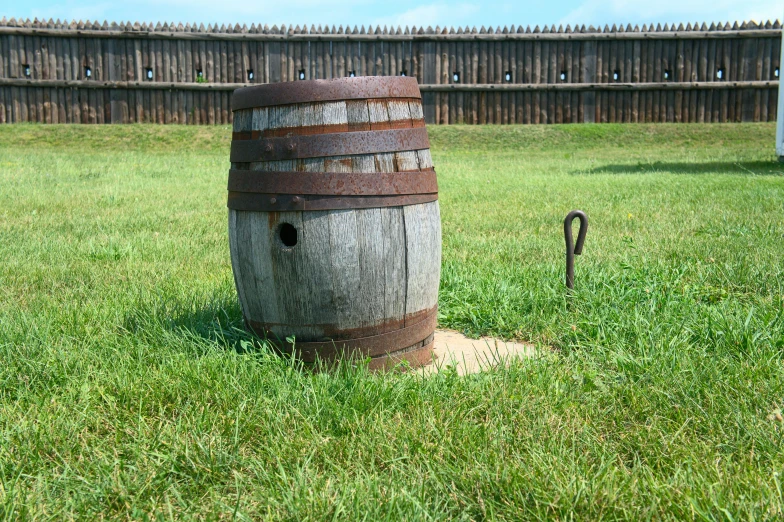 the barrel is sitting in the middle of the grass