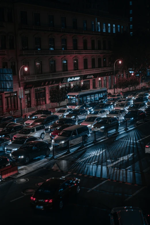 city street at night with cars stopped and buses passing