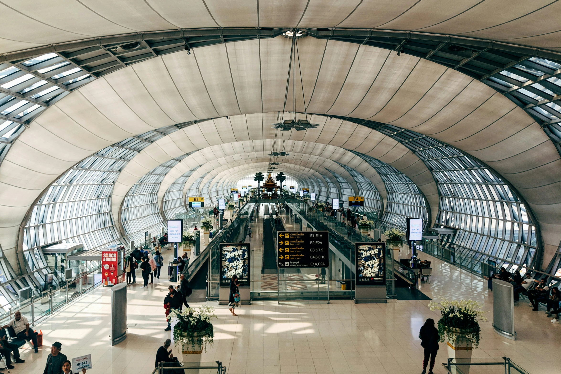 passengers walk through a covered walkway at the airport