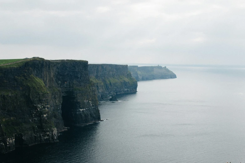 cliffs on a wide river surrounded by fog and water