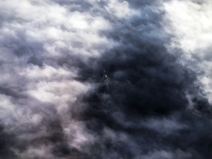 a big kite is flying in a very cloudy sky