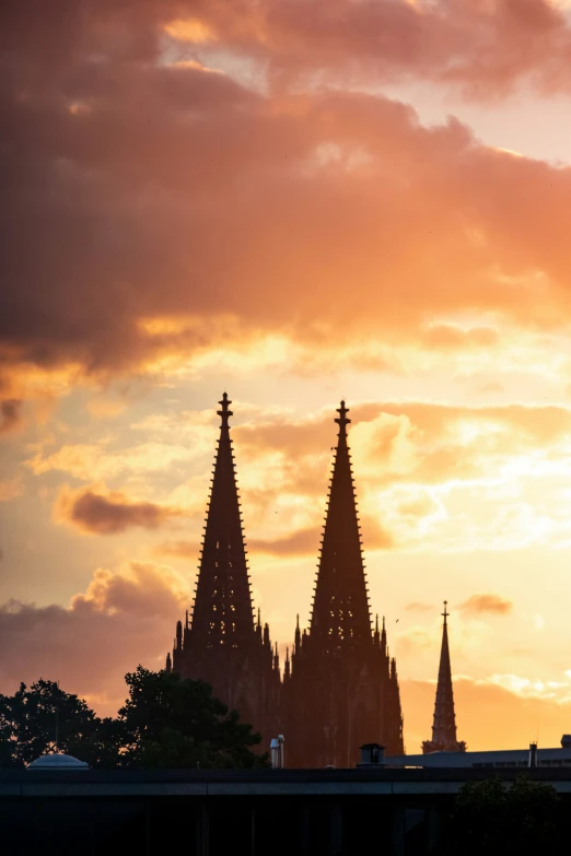 the sun shining behind silhouettes the steeple of a church