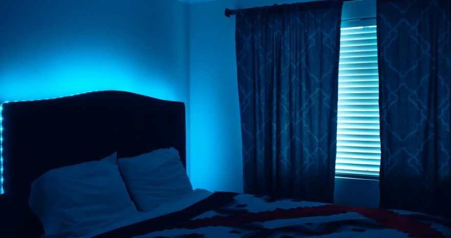 an empty bed lit by the blue light
