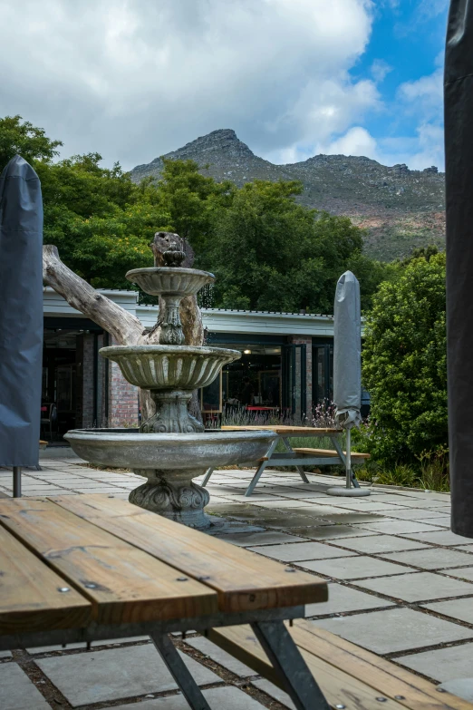 a fountain on the side of a building with a bench in front of it