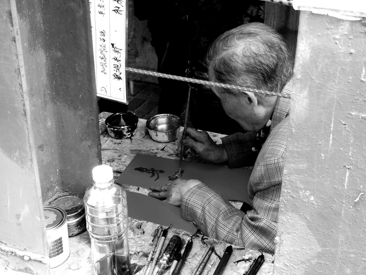 a man looking through a window while painting