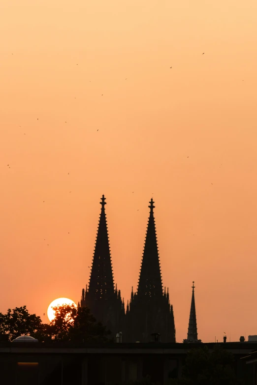 the sun shining behind an old cathedral with spires