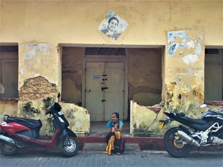 a woman sitting in the shade of her motorcycle