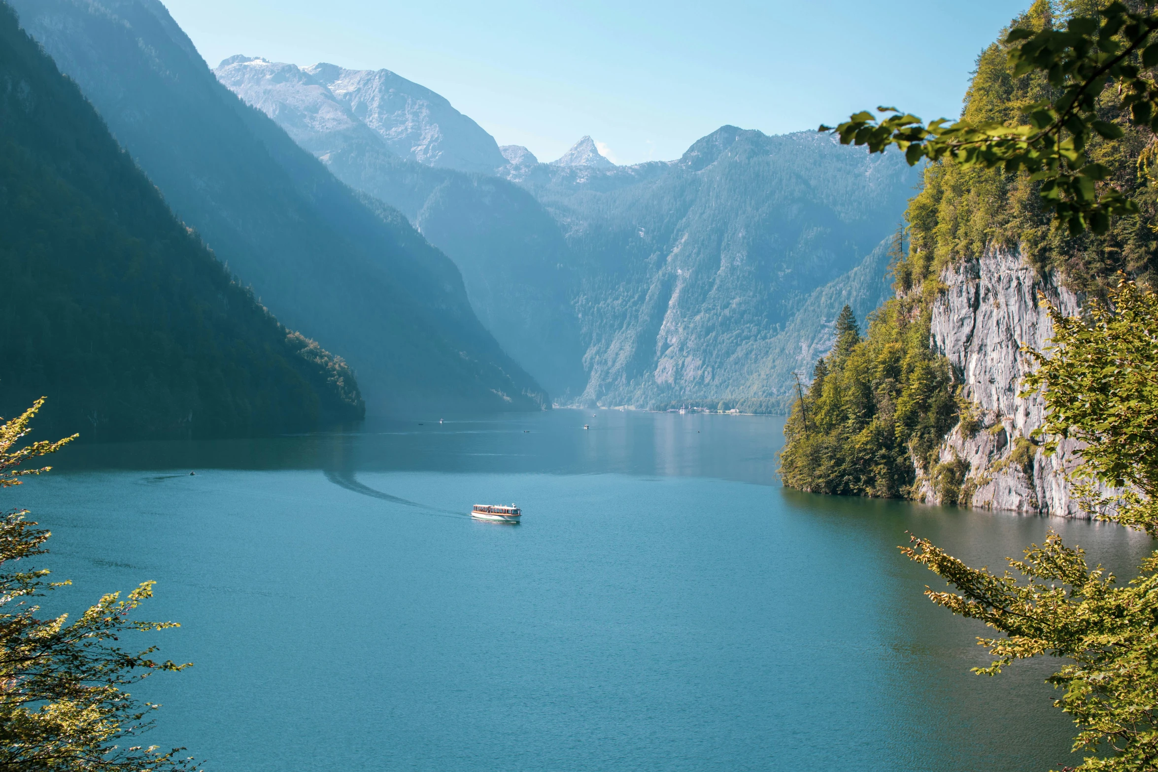 the small boat is traveling through the middle of the lake