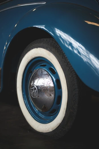 a blue old fashioned vehicle with two white tires