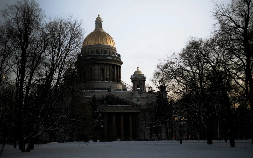 an old building with gold dome, in the middle of snowy area