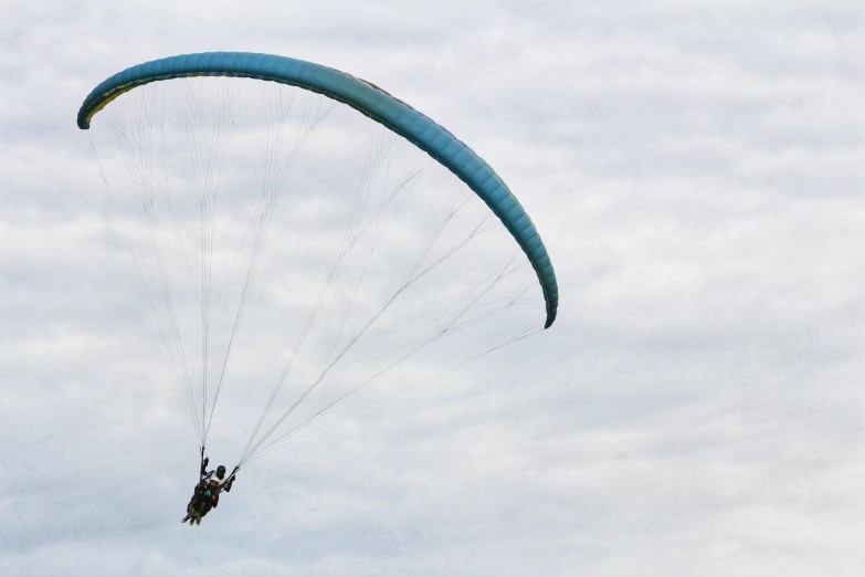 someone is para - sailing on the water on a cloudy day