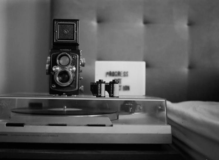 black and white pograph of a portable camera sitting on top of a record player