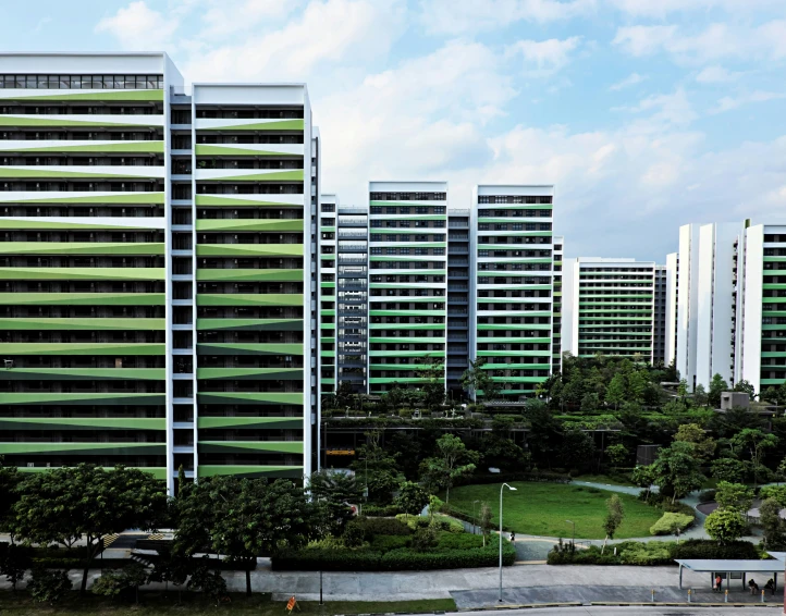 green and white buildings with trees in the foreground